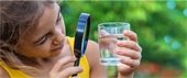 Girl examining glass of water